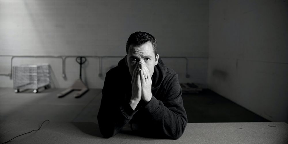 zmartwiony mężczyzna chowa twarz w dłoniach