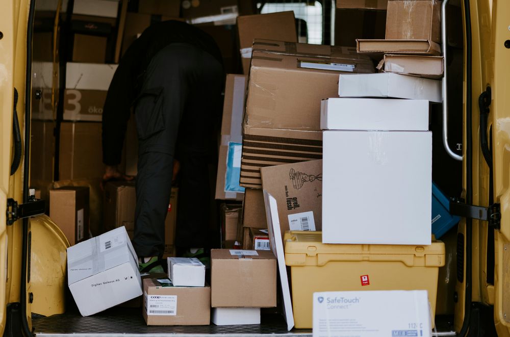 paczki w samochodzie kurierskim jadą do automatu paczkowego zdjęcie:claudio-schwarz-unsplash, CC-0